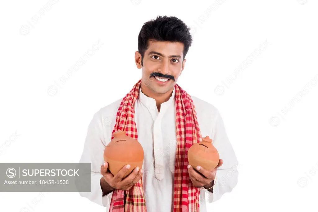 Portrait of a man carrying piggy bank in both hands