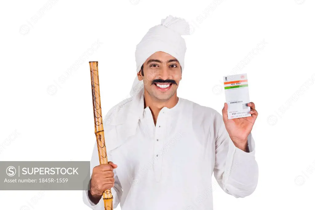 Portrait of a man showing an Aadhaar Card and smiling