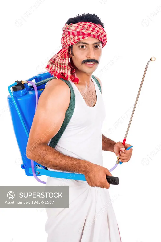 Portrait of a farmer carrying crop sprayer
