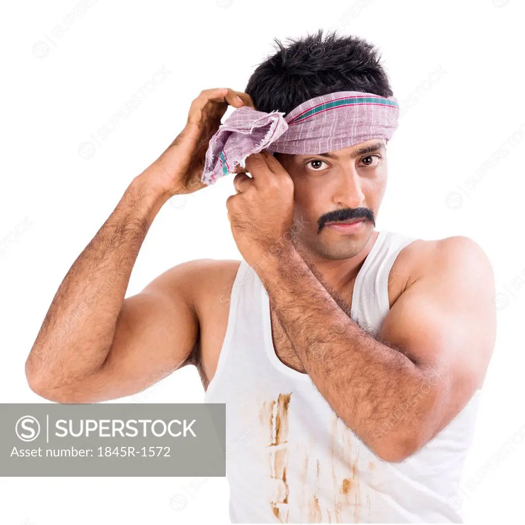 Portrait of a farmer tying cloth on his head