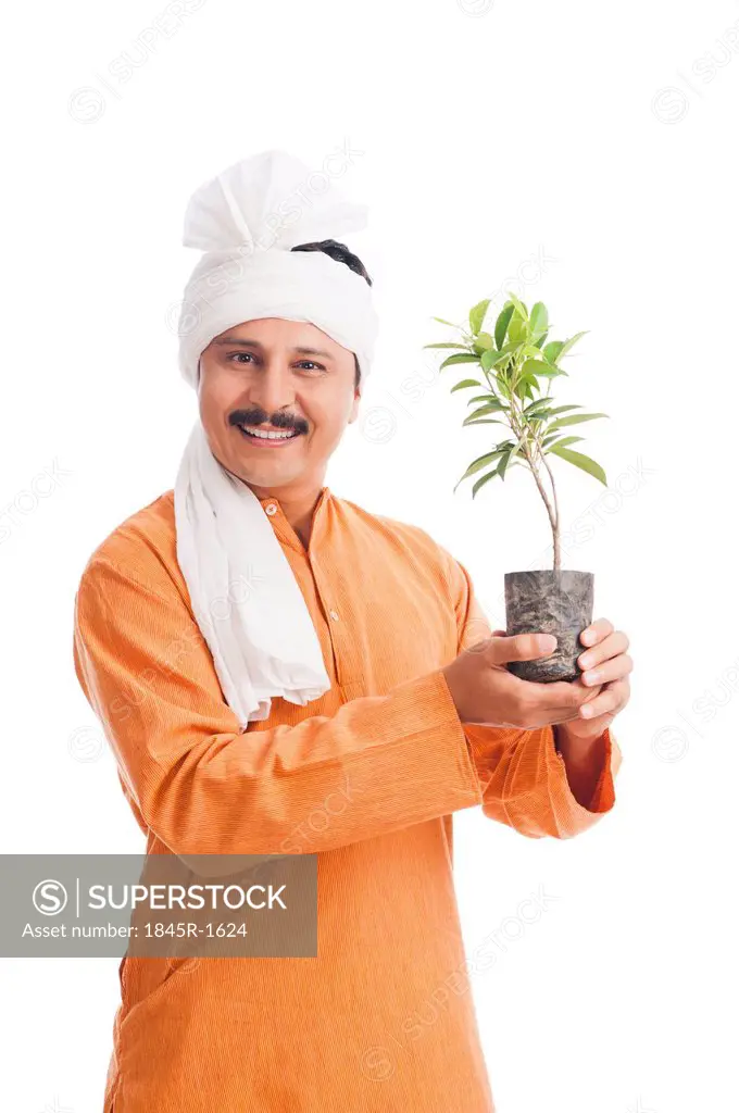 Portrait of a farmer holding a potted plant and smiling