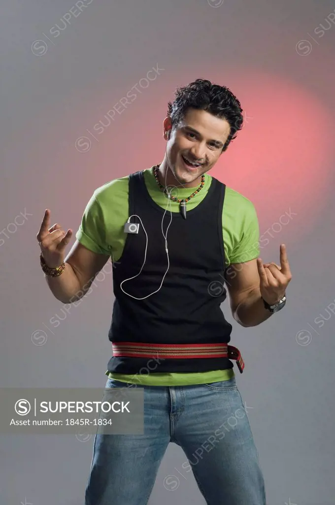 Man listening to music and gesturing 'Rock and Roll' sign