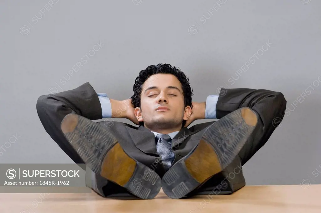 Businessman napping with his feet on desk
