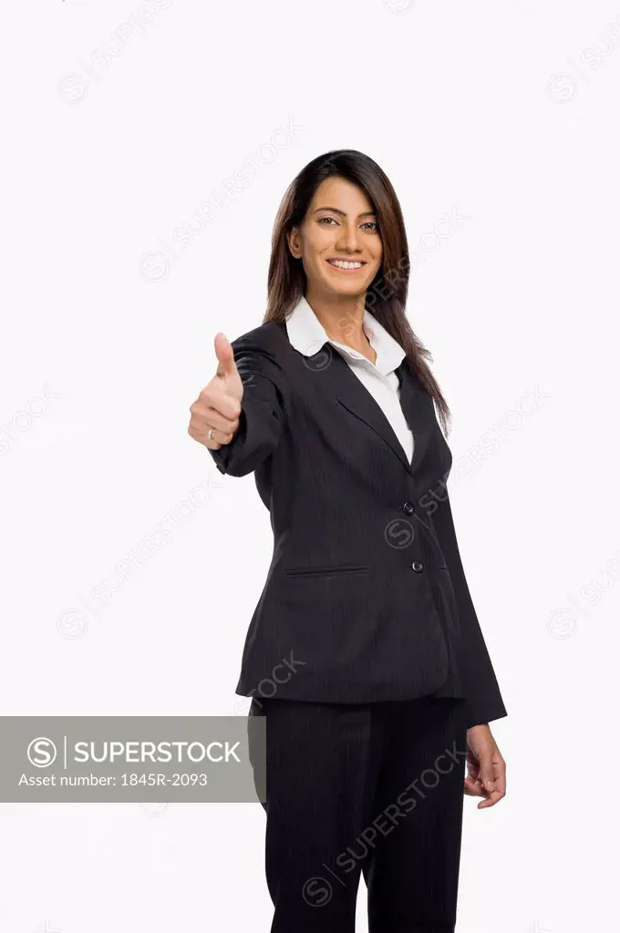 Businesswoman showing thumbs up sign and smiling
