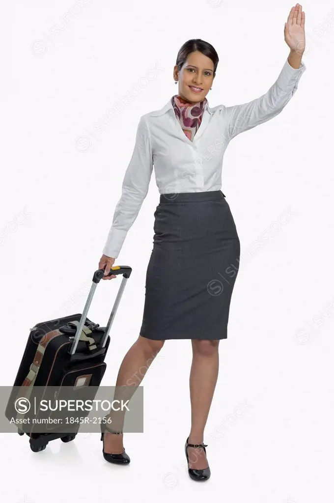 Air hostess carrying her luggage and waving