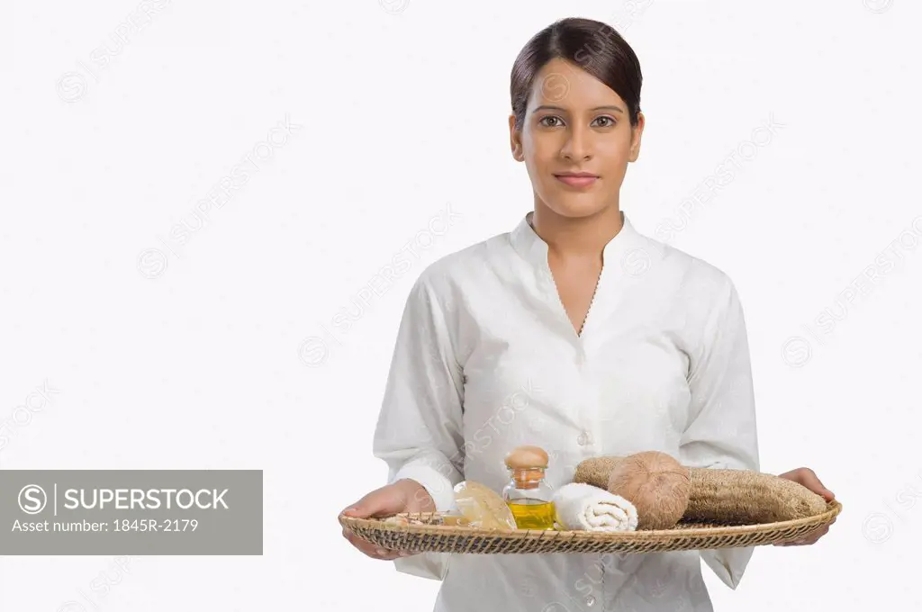 Woman holding a tray of products for aromatherapy