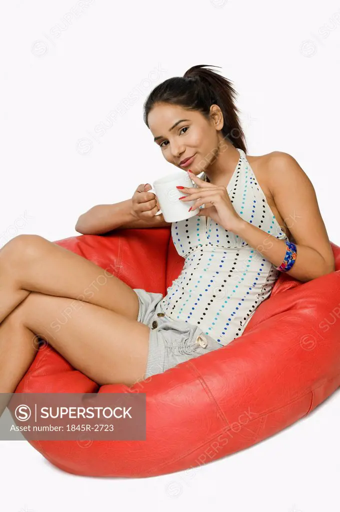 Woman sitting on a bean bag with a cup of coffee