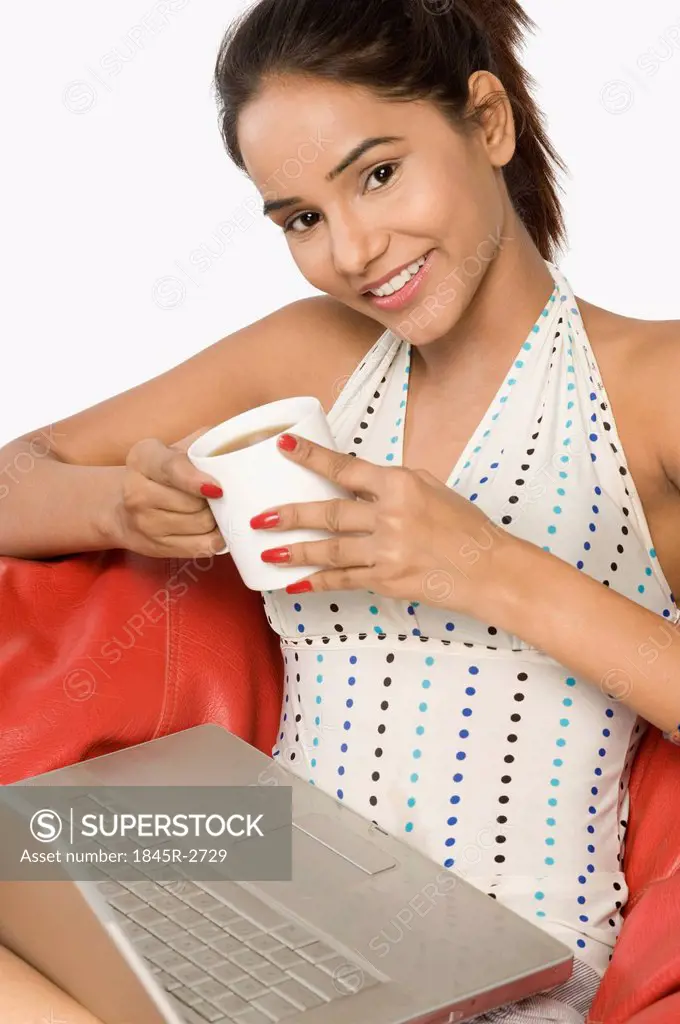 Woman using a laptop with a cup of coffee