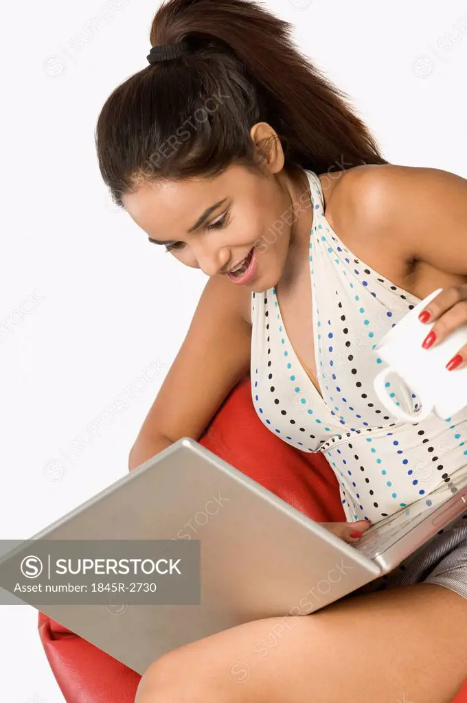 Woman using a laptop with a cup of coffee