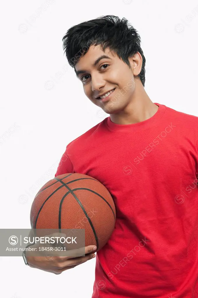Portrait of a man holding a basket ball and smiling