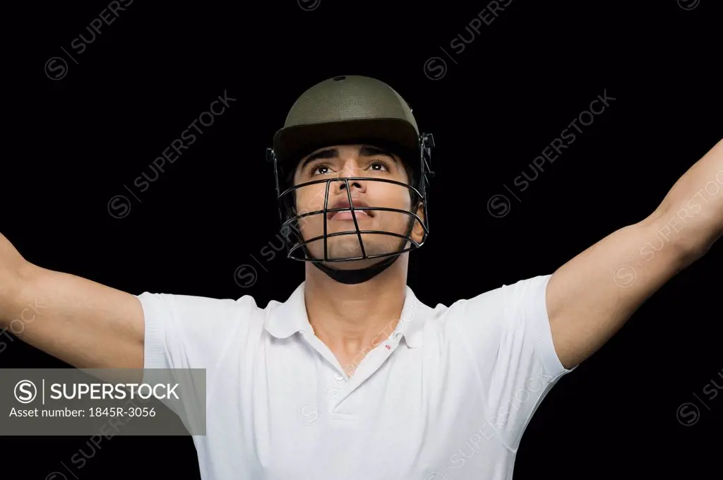 Cricket batsman celebrating with his arms raised