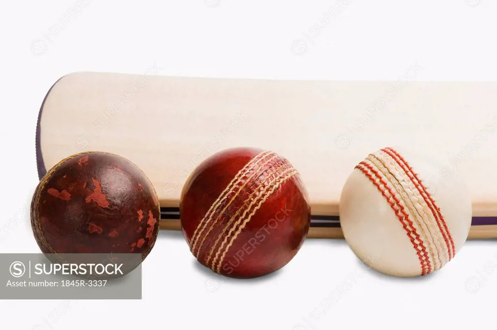 Close-up of cricket balls with a bat