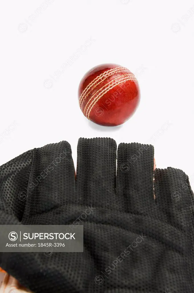 Close-up of a cricket ball and a wicket keeping glove