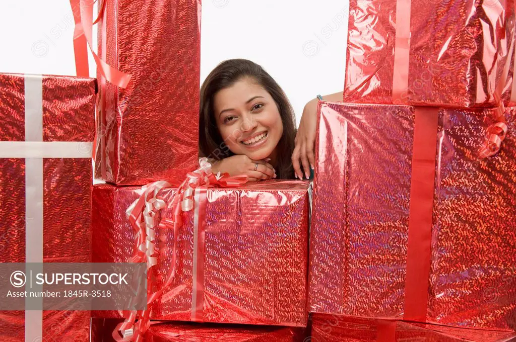 Portrait of a woman smiling behind gift boxes