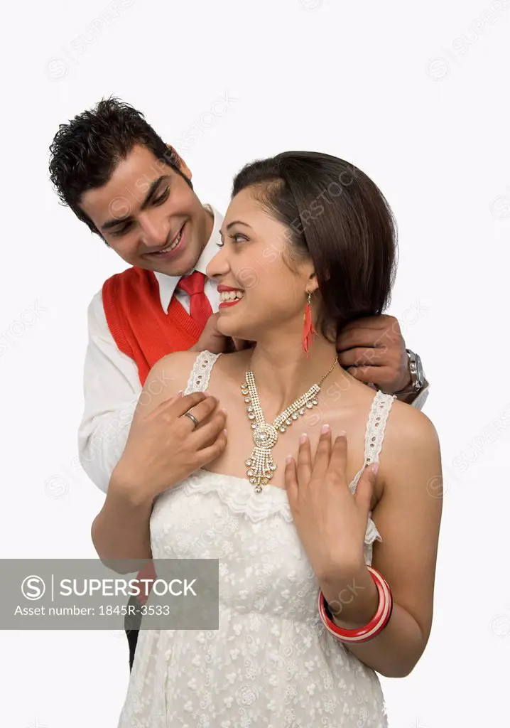 Man putting the necklace in his girlfriend's neck
