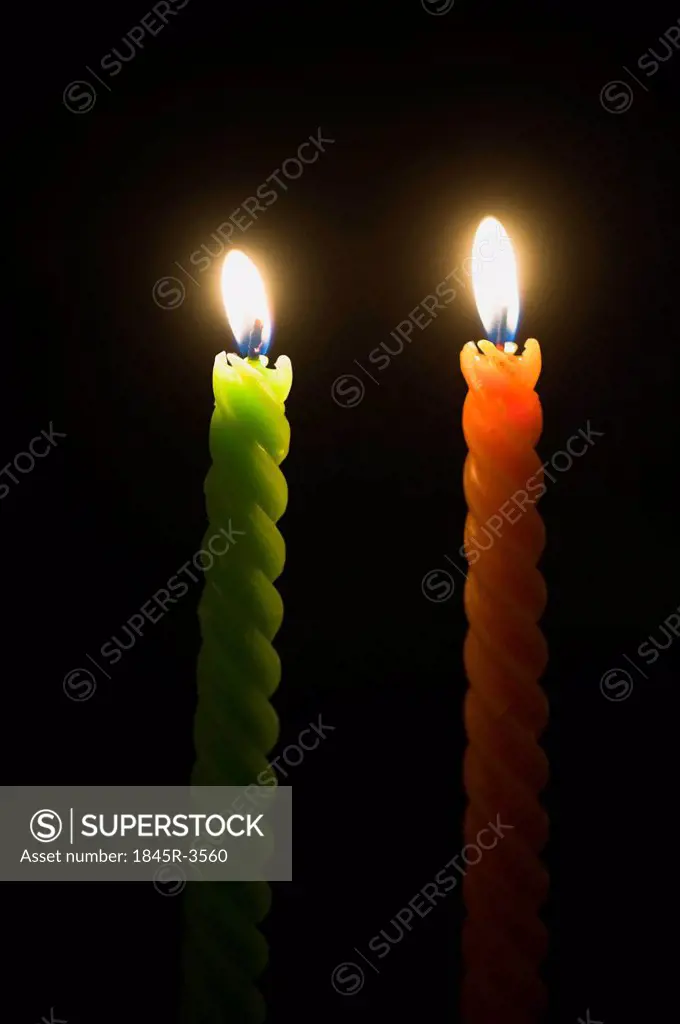 Close-up of two burning candles