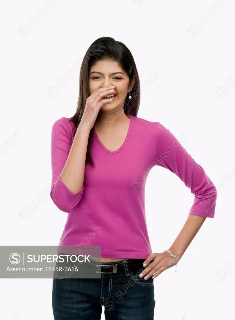 Close-up of a woman laughing with her hand on her mouth