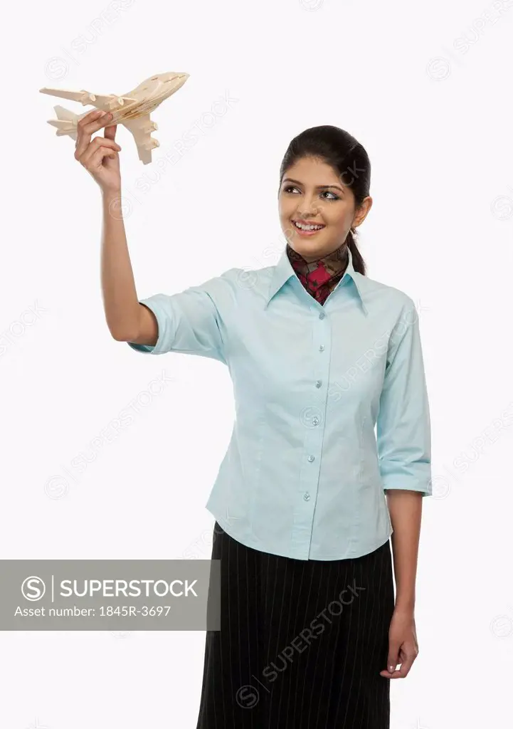 Female flight attendant flying a toy airplane