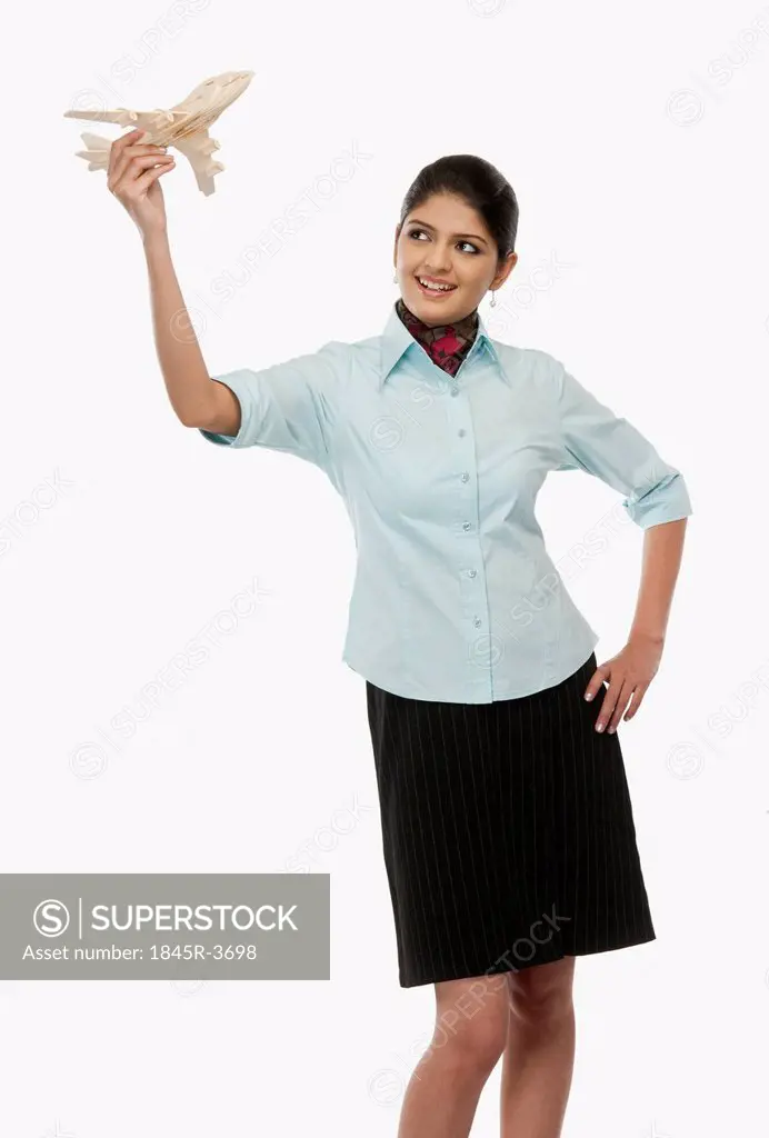Female flight attendant flying a toy airplane