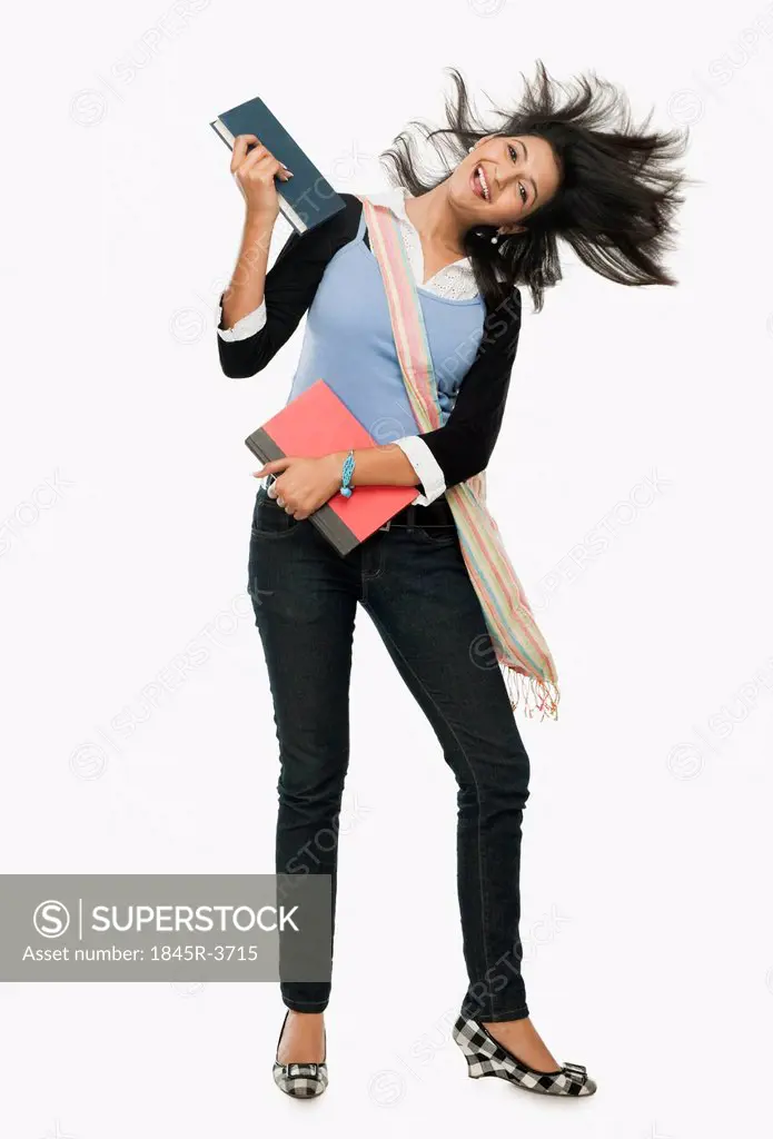 University student holding books and looking excited