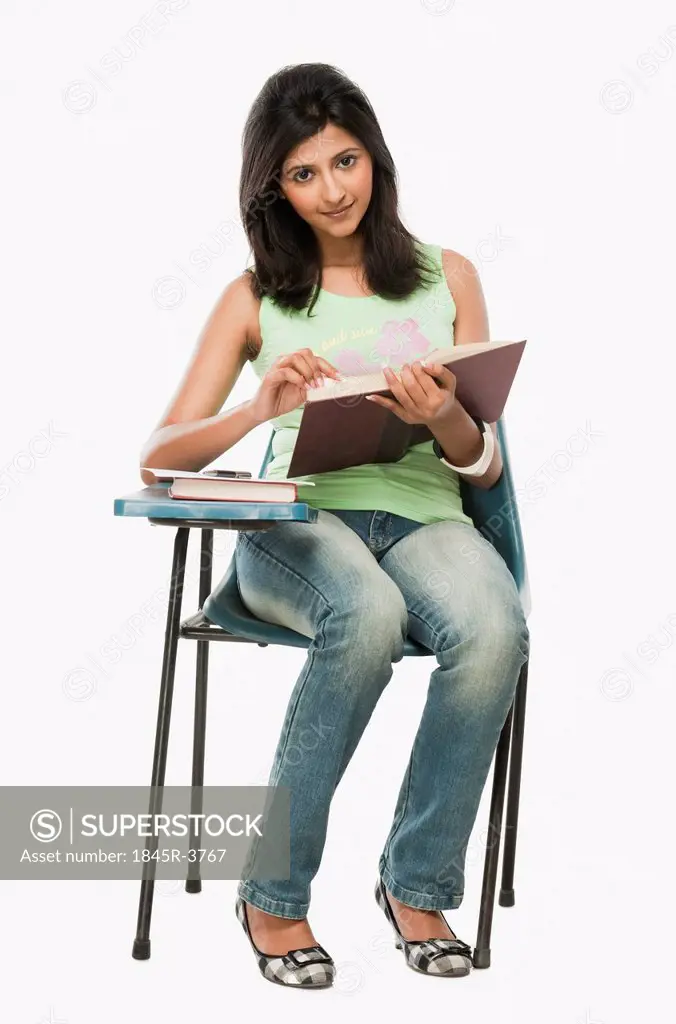 University student reading a book in a classroom