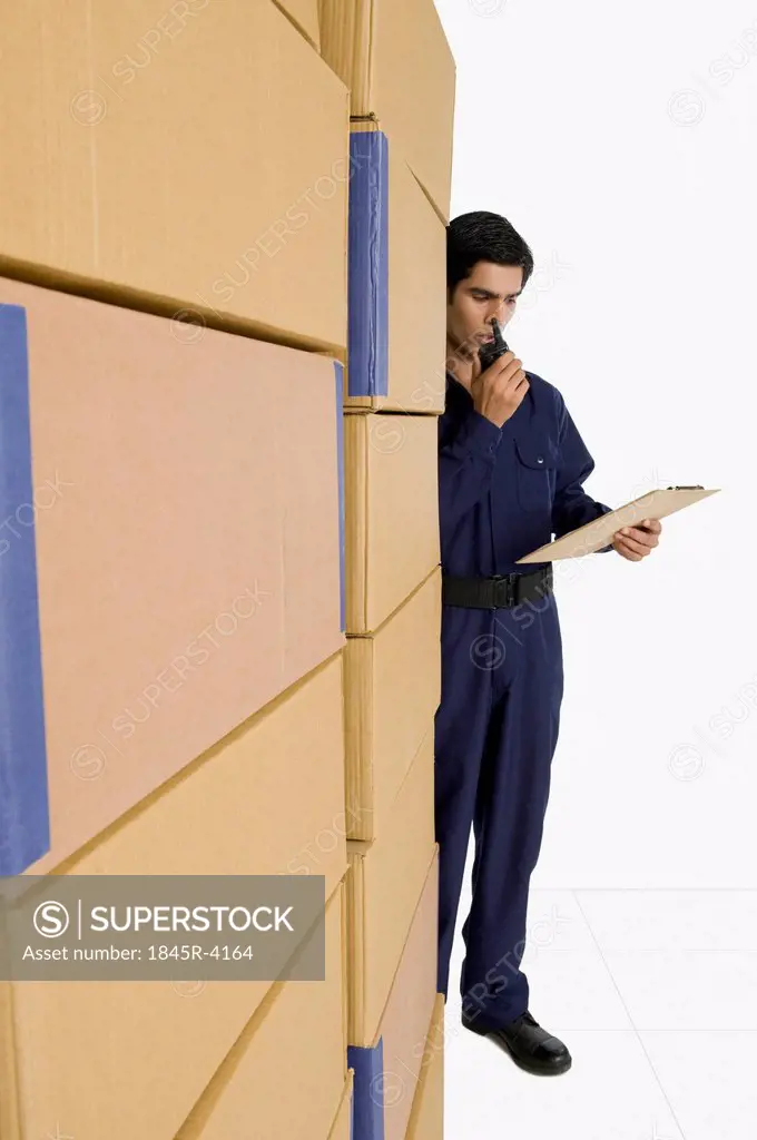 Store in charge talking on a walkie-talkie in a warehouse