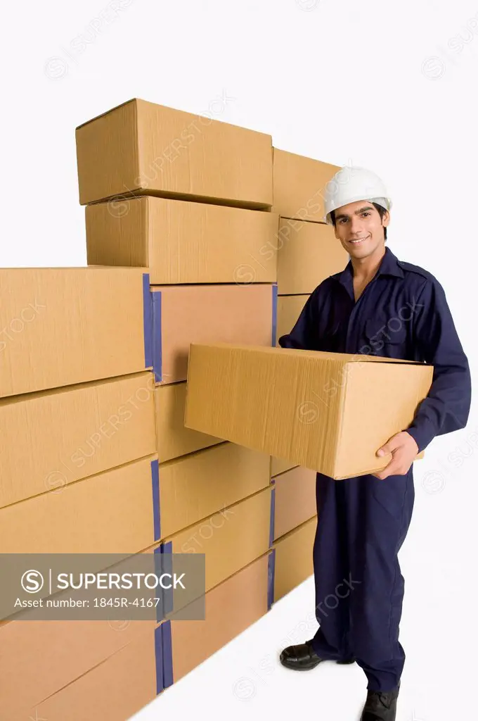 Store in charge carrying a cardboard box in a warehouse