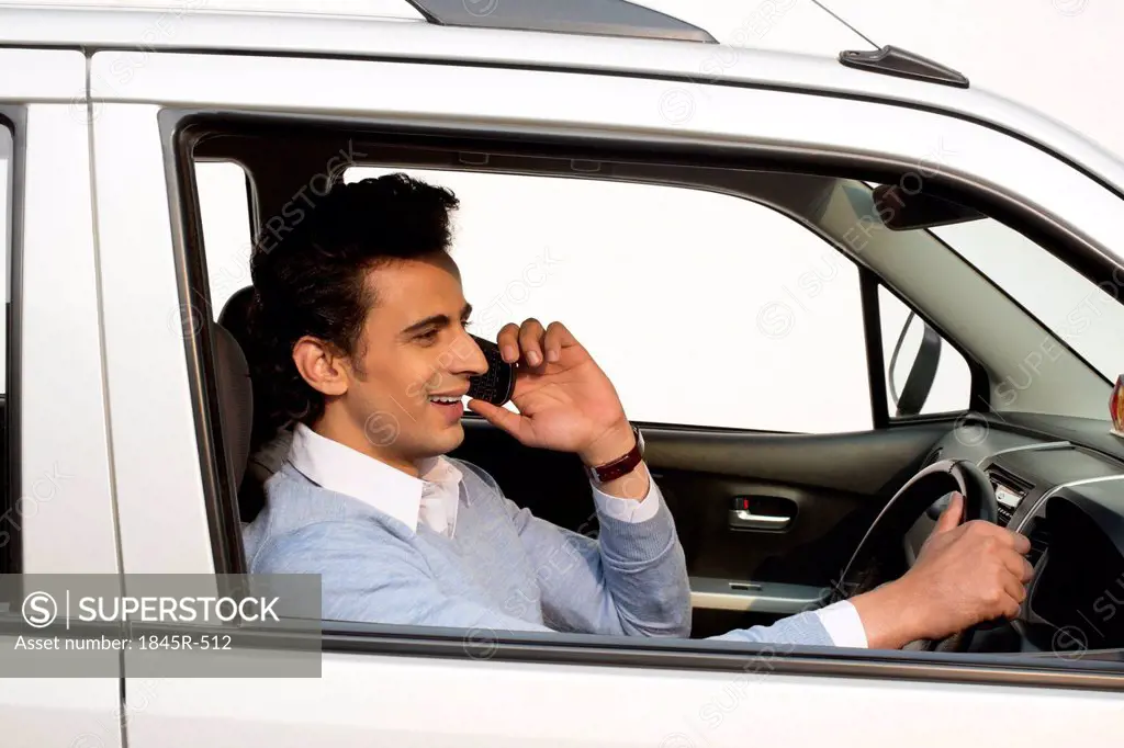 Man talking on a mobile phone while driving a car