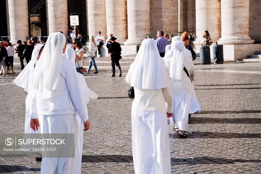 Rear view of nuns walking at a square, Berninis Column, St. Peters Square, Vatican City