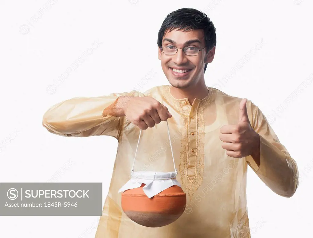 Bengali man carrying a pot of rasgulla and showing thumbs up sign
