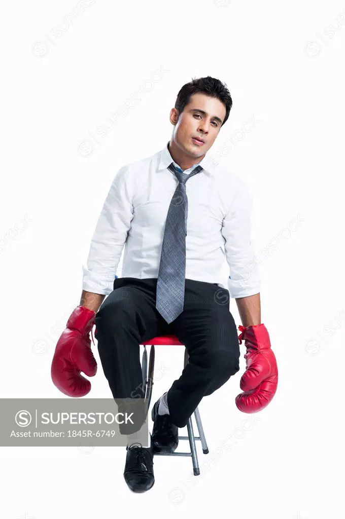 Businessman wearing boxing gloves and looking sad