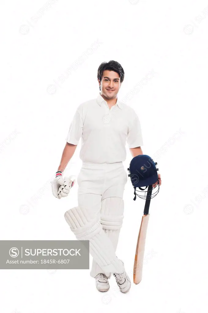 Batsman holding a cricket bat with sports helmet and smiling