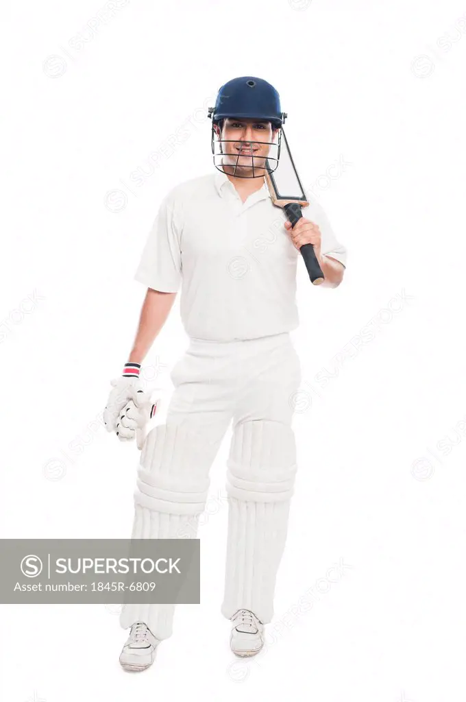 Portrait of a batsman standing with holding a cricket bat and smiling