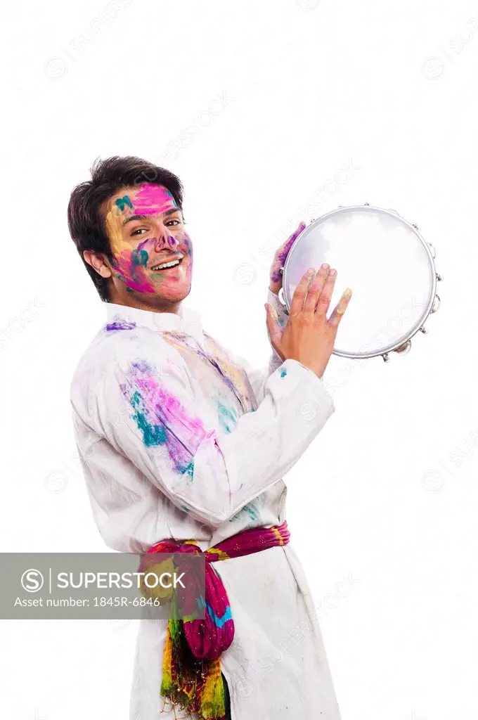 Man celebrating Holi with playing tambourine