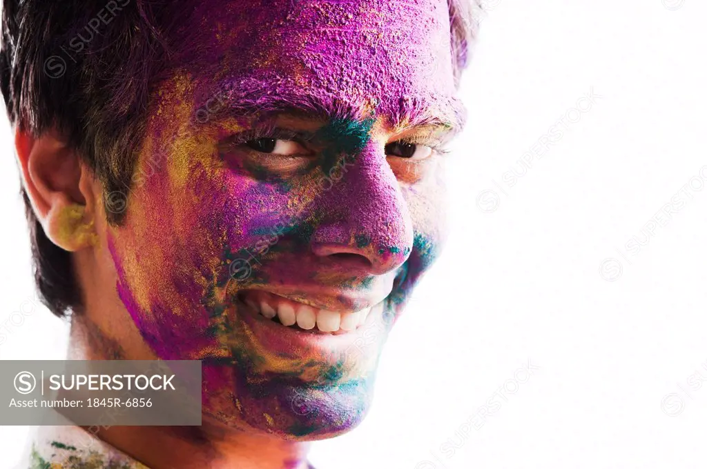 Mans face covered with powder paint during Holi festival