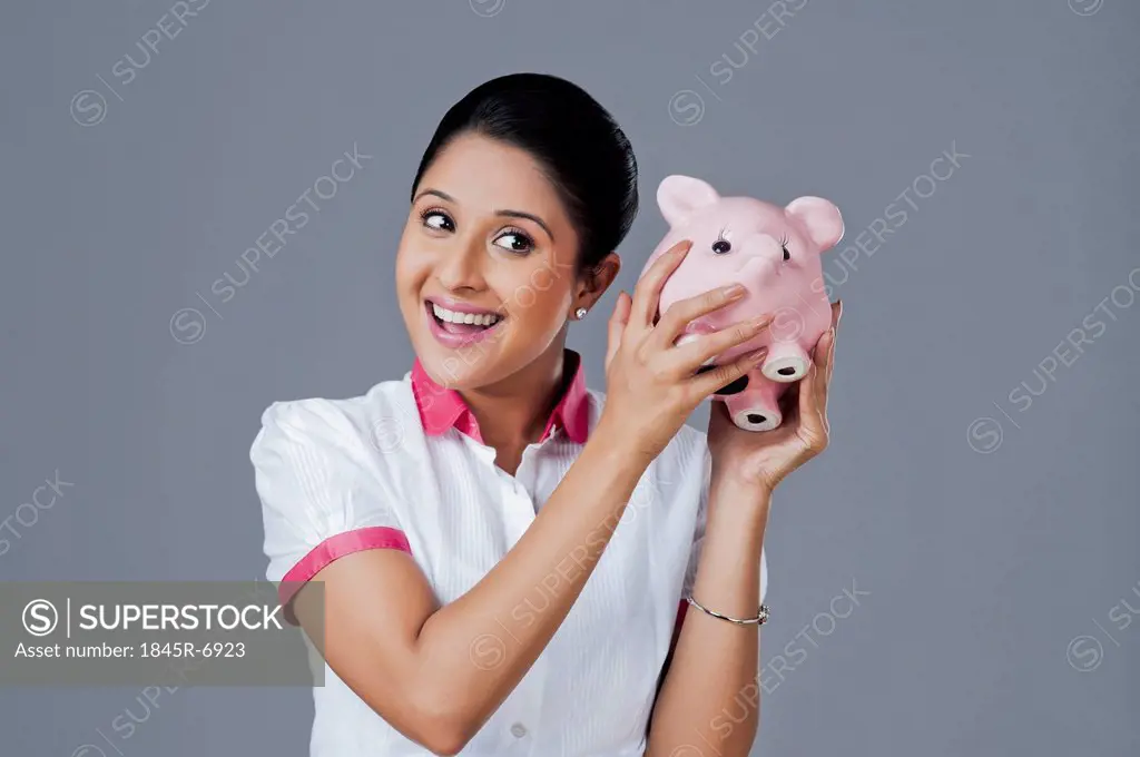 Woman shaking a piggy bank