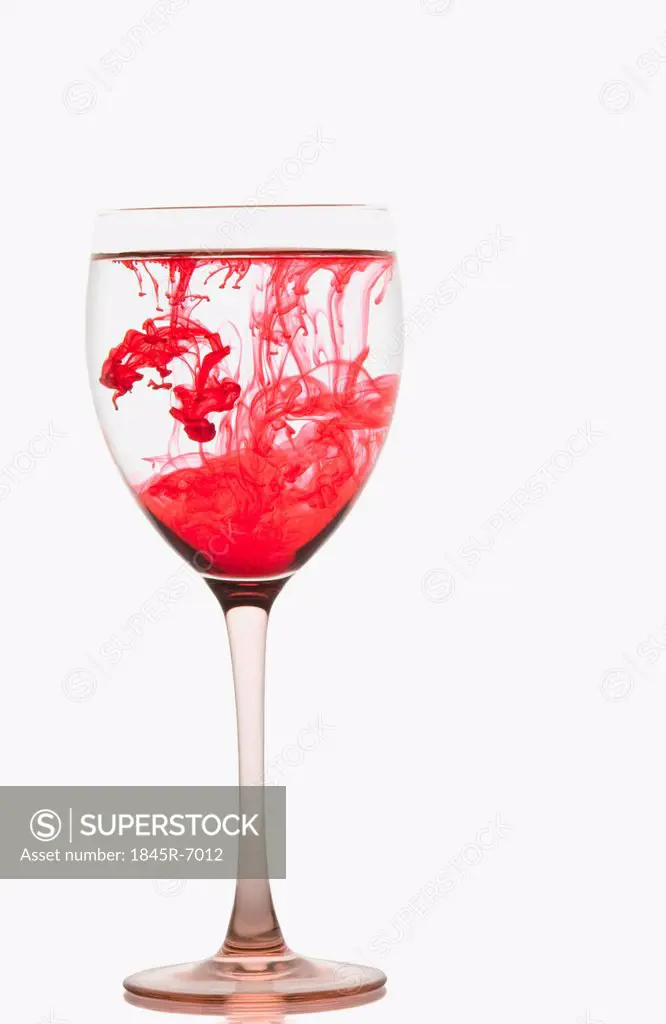 Red color streaks with water in a wine glass