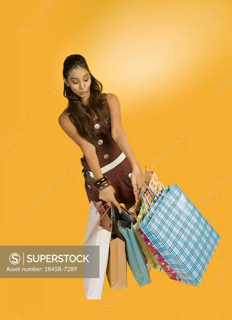 Woman holding shopping bags and pointing