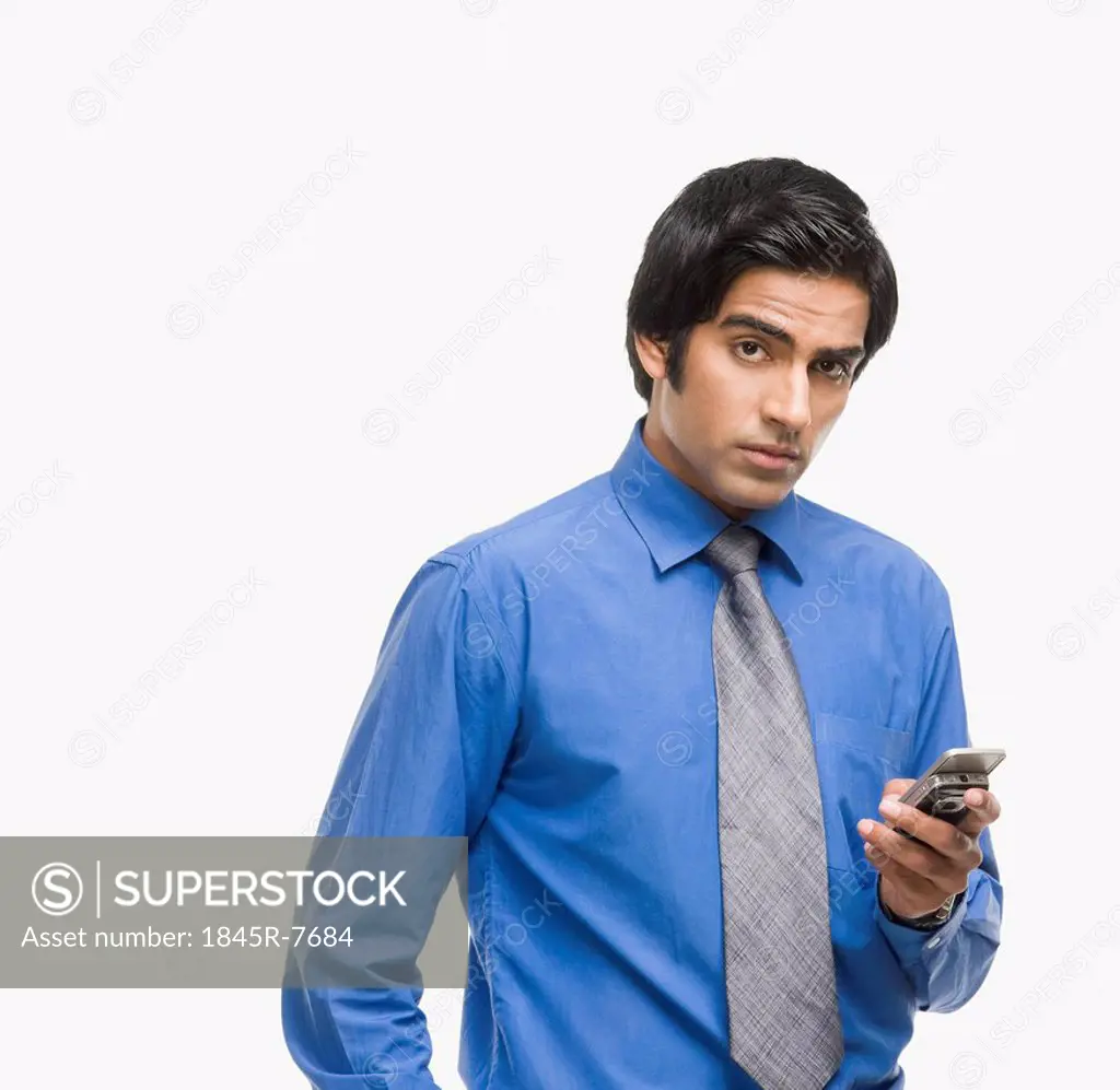 Portrait of a businessman text messaging on a mobile phone