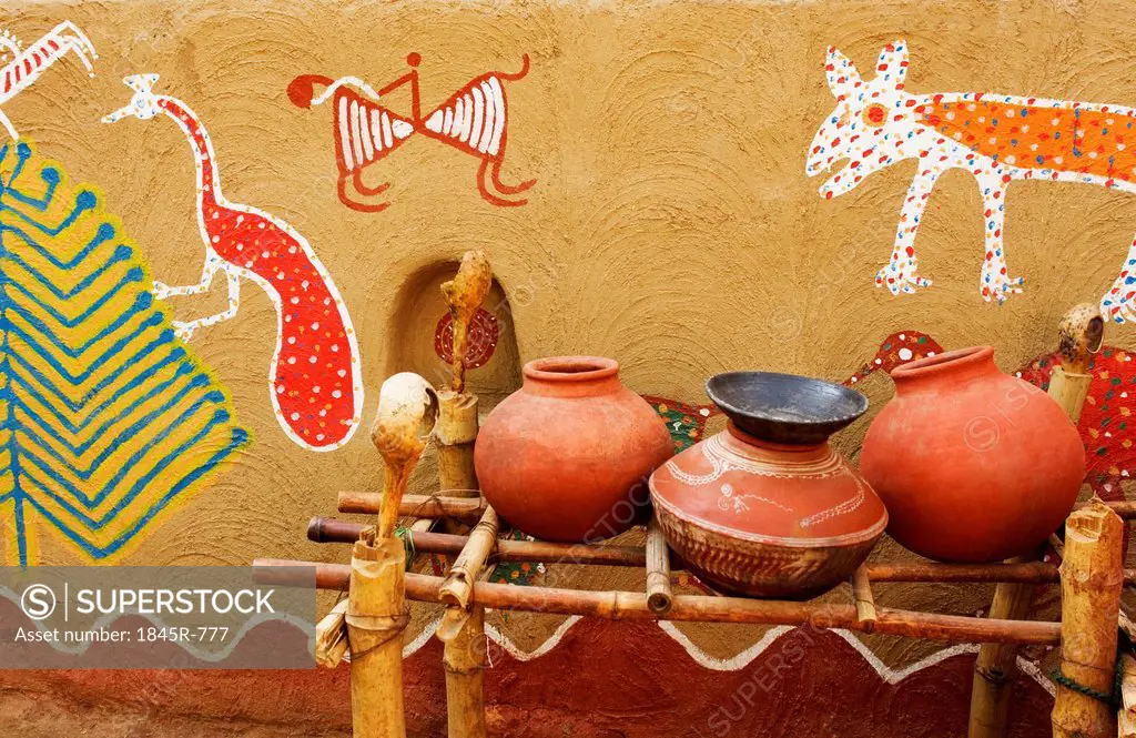 Clay water pots in front of a wall with mural