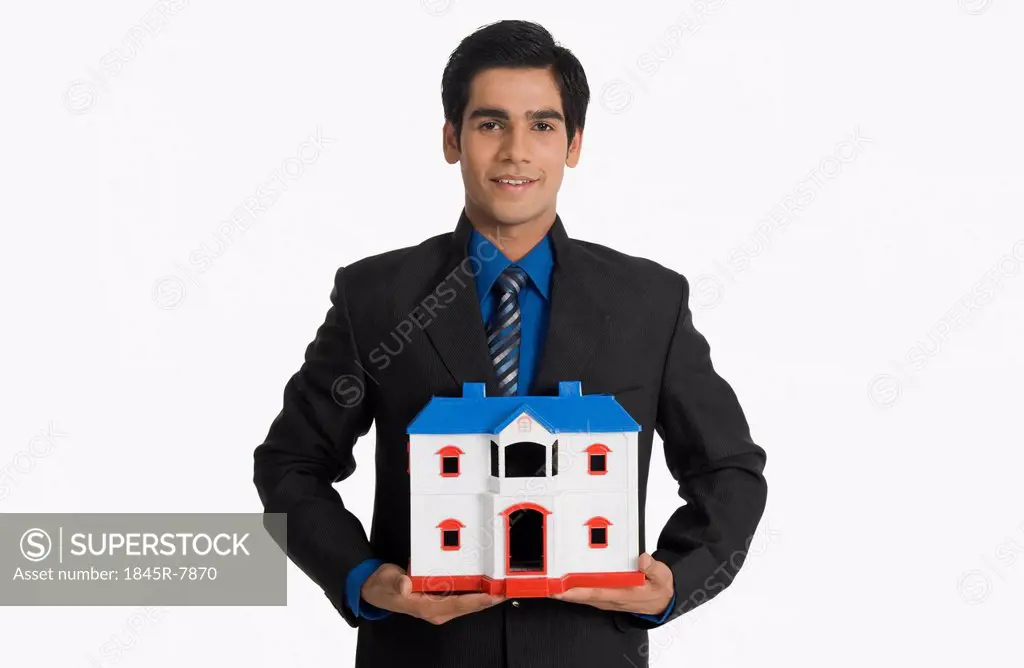Real estate agent holding a model home