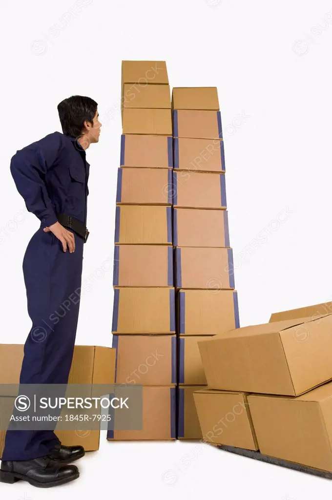 Rear view of a store in charge looking at cardboard boxes