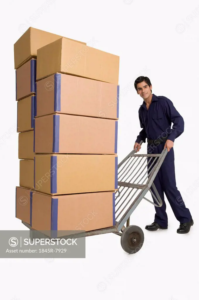 Storekeeper carrying cardboard boxes on a hand truck