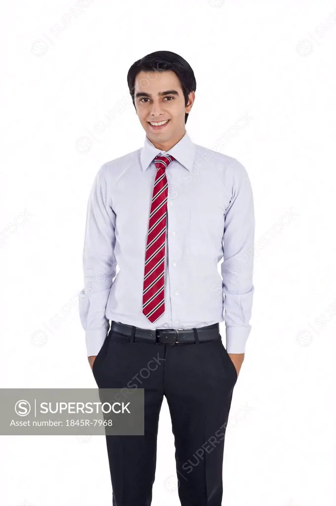 Businessman standing with his hands in pockets and smiling