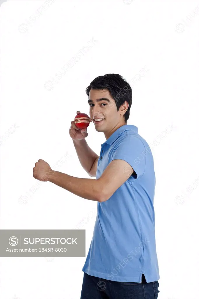 Man throwing a cricket ball and smiling