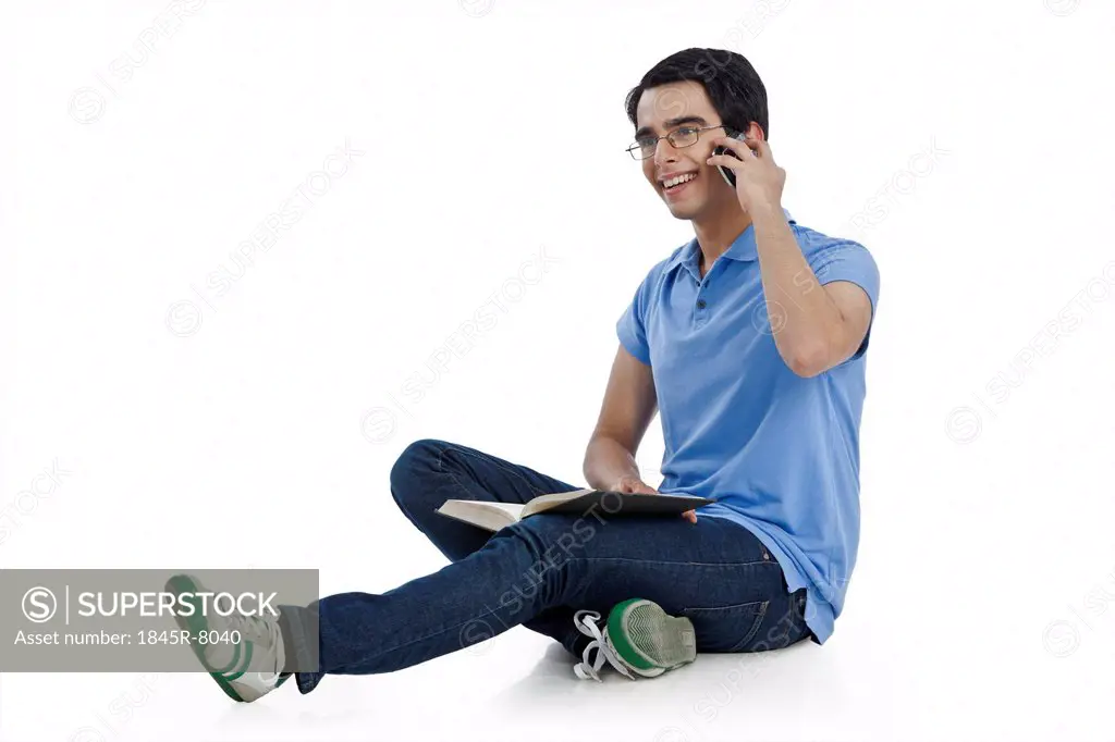 Man sitting on the floor and talking on a mobile phone