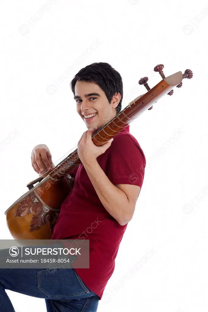 Man playing a sitar and smiling