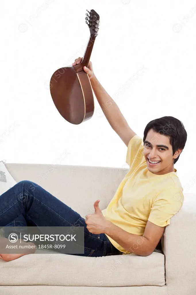 Happy man holding a mandolin and showing thumbs up sign