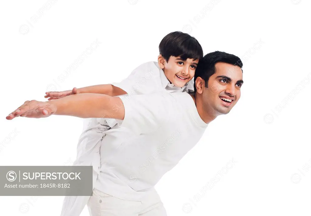 Happy boy riding piggyback on his father