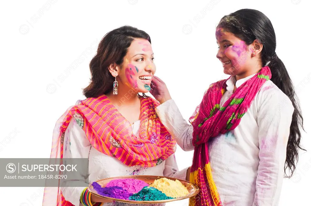 Woman celebrating Holi festival with her daughter